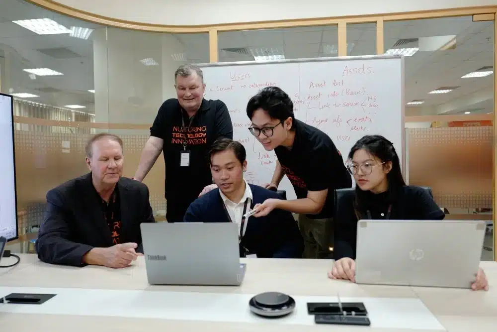 PowerGate Software team members discussing user and asset planning on a whiteboard