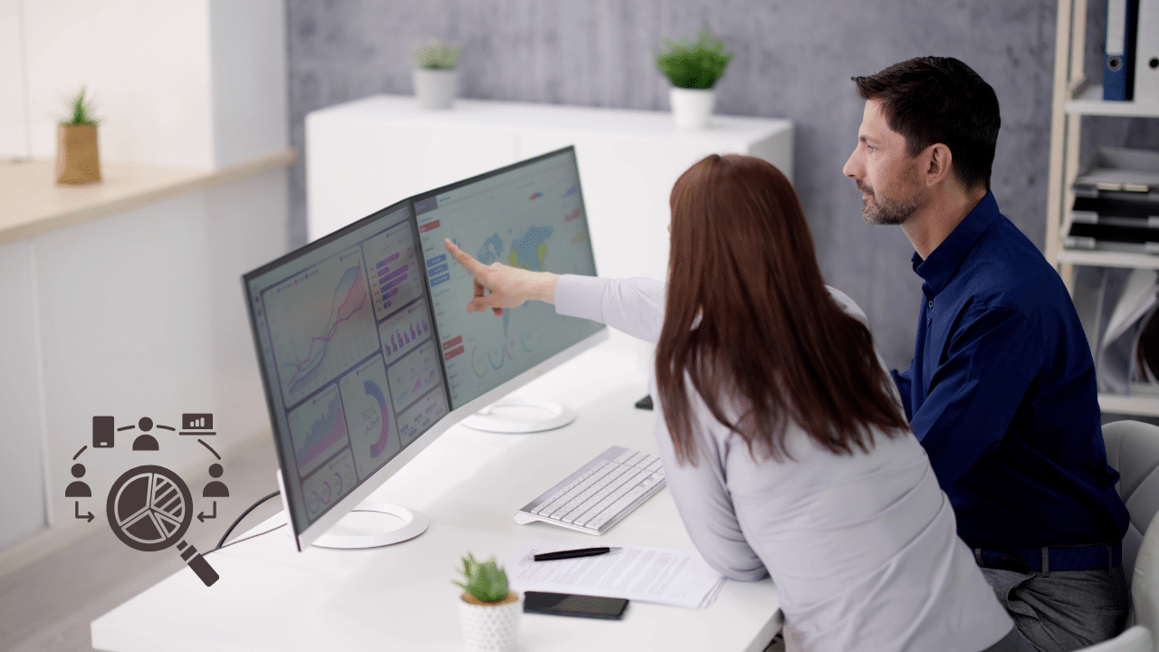 A business intelligence team analyzing technographic data vs intent data dashboards on dual monitors to optimize a sales pipeline.